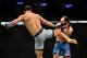Paulo Costa (left) kicks Johny Hendricks (right)