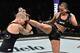 Ashlee Evans-Smith (right) kicks Bec Rawlings en route to her unanimous-decision victory.