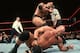 The Rock stomping Steve Austin into the mat.