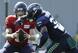 Seattle Seahawks running back Chris Carson takes a handoff from quarterback Alex McGough.