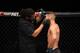 Referee Herb Dean (left) checks Jeremy Stephens