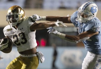 Notre Dame's Kyren Williams (23) rushes past North Carolina's Jeremiah Gemmell (44) during the fourth quarter of an NCAA college football game Friday, Nov. 27, 2020, in Chapel Hill, N.C. (Robert Willett/The News & Observer via AP, Pool)